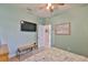 Comfortable bedroom featuring light-green walls and a mounted television at 6516 Salt Creek Ave, Apollo Beach, FL 33572