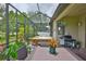 Enclosed patio featuring a hot tub, outdoor dining set, barbeque grill, and lovely garden and pond views at 6516 Salt Creek Ave, Apollo Beach, FL 33572