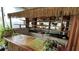 Unique bar area featuring an intricate thatched roof, open shelving, and a charming bamboo facade at 1743 Arabian Ln, Palm Harbor, FL 34685