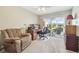 Bedroom featuring an office desk and chair, a comfy recliner, and outdoor view through screened windows at 326 Caloosa Woods Ln, Sun City Center, FL 33573