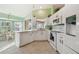 Well-lit kitchen with white cabinetry, modern appliances, and a breakfast nook at 326 Caloosa Woods Ln, Sun City Center, FL 33573