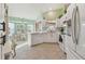 Bright kitchen with white cabinetry, modern appliances, tile floor, and a breakfast nook at 326 Caloosa Woods Ln, Sun City Center, FL 33573