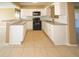 Bright kitchen featuring white cabinetry, granite countertops, and modern black appliances at 7323 Belvedere Ter, New Port Richey, FL 34655