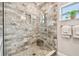 Luxurious shower with marble tile, glass enclosure, and a built-in niche for toiletries at 487 9Th N Ave, St Petersburg, FL 33701