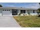 Charming single-story home with attached garage, driveway, manicured lawn and decorative white window shutters at 123 9Th St, Belleair Beach, FL 33786