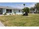 Lovely one-story home with manicured lawn, palm trees, white rock landscaping, and decorative white window shutters at 123 9Th St, Belleair Beach, FL 33786