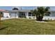 Inviting single-story home with a lush green lawn and bright white garage door at 123 9Th St, Belleair Beach, FL 33786