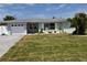 Beautiful single-story home with a manicured lawn and a white garage door at 123 9Th St, Belleair Beach, FL 33786