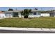 Charming single-story house featuring a well-kept lawn and lush landscaping near the street at 123 9Th St, Belleair Beach, FL 33786