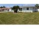 Charming home with a manicured lawn, palm trees, white rock landscaping, and decorative white window shutters at 123 9Th St, Belleair Beach, FL 33786