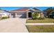 Charming single-story home featuring a two-car garage, stone accents, and a well-maintained lawn at 17671 Bright Wheat Dr, Lithia, FL 33547