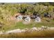 Aerial view highlighting lakeside gazebos and sandy shoreline surrounded by trees, creating a peaceful retreat at 2972 Lake Saxon Dr, Land O Lakes, FL 34639
