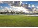 Aerial view of sprawling horse property with lush green pastures, white fencing, and a tranquil pond at 2972 Lake Saxon Dr, Land O Lakes, FL 34639