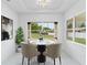 Bright dining room featuring a modern table, stylish chairs, and views of the green outdoors at 2972 Lake Saxon Dr, Land O Lakes, FL 34639