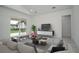 Bright living room featuring vaulted ceilings, tile floors, and sliding doors leading to backyard at 2972 Lake Saxon Dr, Land O Lakes, FL 34639