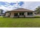 The rear exterior features a covered patio, well-maintained lawn, and neutral siding with contrasting trim at 2972 Lake Saxon Dr, Land O Lakes, FL 34639