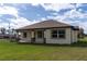 The rear exterior features a covered patio, well-maintained lawn, and neutral siding with contrasting trim at 2972 Lake Saxon Dr, Land O Lakes, FL 34639