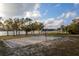 Outdoor sand volleyball court with a lake view, complemented by shaded picnic areas and mature trees at 2972 Lake Saxon Dr, Land O Lakes, FL 34639
