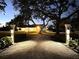 Well-lit, gated entrance on lush property creates a warm and inviting atmosphere at 724 Bayshore Dr, Terra Ceia, FL 34250