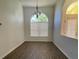 Dining room featuring hardwood floors, a modern chandelier, and a large window, creating an elegant dining space at 3447 Loveland Blvd, Port Charlotte, FL 33980