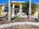 Close up of front exterior, showing the light blue double doors, white columns, and landscaping of the home at 3447 Loveland Blvd, Port Charlotte, FL 33980