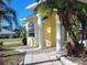 Side view of the home showing the white columns and arched window, with the sidewalk leading to the front door at 3447 Loveland Blvd, Port Charlotte, FL 33980