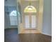 Inviting foyer with a high arch and double doors, tiled floor entryway, and view to the living area at 3447 Loveland Blvd, Port Charlotte, FL 33980
