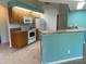 Bright kitchen featuring wooden cabinets, white appliances, and a breakfast bar with a stone countertop at 3447 Loveland Blvd, Port Charlotte, FL 33980