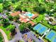 Aerial view showcasing the community amenities including the pool, tennis courts, and clubhouse nestled in lush greenery at 3464 Sutherland Dr, Palm Harbor, FL 34684