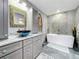 Bathroom showcasing a modern vanity with unique vessel sink and a luxurious soaking tub at 6723 Mango S Ave, St Petersburg, FL 33707