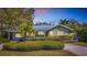 Charming home with a metal roof, manicured landscaping and a curved concrete driveway at sunset at 6723 Mango S Ave, St Petersburg, FL 33707