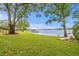 Backyard featuring dock, boat lift, lake swing with mature trees and well maintained yard at 11710 N Armenia Ave, Tampa, FL 33612