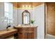 Cozy bathroom featuring wooden vanity with mirror, tile countertops, and decorative orchids at 11710 N Armenia Ave, Tampa, FL 33612
