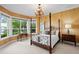A sun-filled bedroom with a four-poster bed, bay window and decorative chandelier at 11710 N Armenia Ave, Tampa, FL 33612