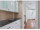 A butler pantry features granite countertops and glass front upper cabinets providing ample storage at 11710 N Armenia Ave, Tampa, FL 33612