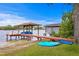 Waterfront dock with a covered boat lift, seating, kayaks, and swing at 11710 N Armenia Ave, Tampa, FL 33612