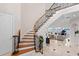 Elegant foyer with a curved staircase, detailed ironwork, and a view into the spacious living room, exuding luxury at 11710 N Armenia Ave, Tampa, FL 33612