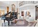 Elegant living room with a grand piano, fireplace, and seating area under a soaring ceiling at 11710 N Armenia Ave, Tampa, FL 33612