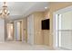 Open living room features neutral walls, TV, chandelier, and doorway access at 11710 N Armenia Ave, Tampa, FL 33612