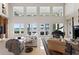 Bright living room with a piano, two stories worth of windows, and lake views for indoor-outdoor living at 11710 N Armenia Ave, Tampa, FL 33612