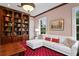Office with a white couch with red pillows, red carpet, a window, and a decorative bookshelf at 11710 N Armenia Ave, Tampa, FL 33612