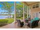 Covered patio with waterfront view featuring a firepit with chairs and tables, framed by manicured landscaping at 11710 N Armenia Ave, Tampa, FL 33612