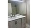 Bathroom showcasing a modern vanity with white countertop, large mirror and tile flooring at 3332 Vorden St, New Port Richey, FL 34655