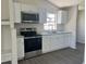 Bright kitchen featuring granite countertops, modern stainless steel appliances and white cabinets at 3332 Vorden St, New Port Richey, FL 34655