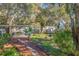 Lush backyard featuring mature trees, garden beds and a covered patio area at 5719 23Rd S Ave, Gulfport, FL 33707