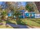 Charming blue single-story home with a well-manicured lawn, white trim, and lush landscaping at 5719 23Rd S Ave, Gulfport, FL 33707
