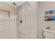 Shower with a white tiled wall, a decorative niche, a shower head, and a picture of a beach scene on the wall at 22 Penzance Ct, Safety Harbor, FL 34695