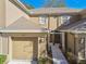 Close-up of a two-story townhome entrance featuring a garage, walkway, and neutral exterior at 4207 Key Thatch Dr, Tampa, FL 33610
