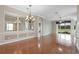 Open-concept dining room boasts hardwood floors, chandelier, and sliding glass doors to the backyard at 4936 Sandy Brook Cir, Wimauma, FL 33598