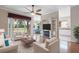 Cozy living room featuring hardwood floors, a ceiling fan, and an entertainment center with a fireplace at 4936 Sandy Brook Cir, Wimauma, FL 33598